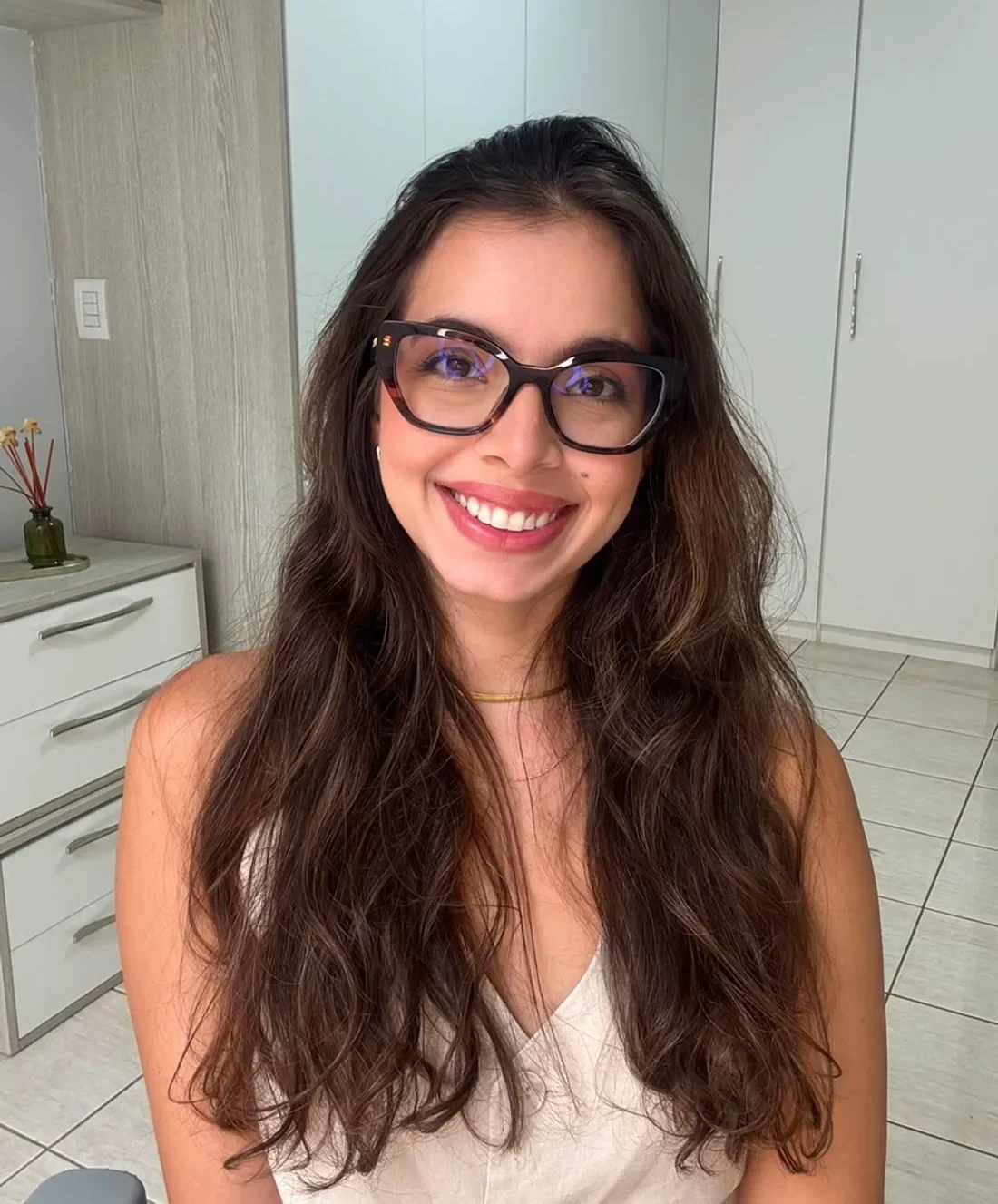 Julia Alcântara, professora de inglês, sorrindo no espaço onde dá as aulas online